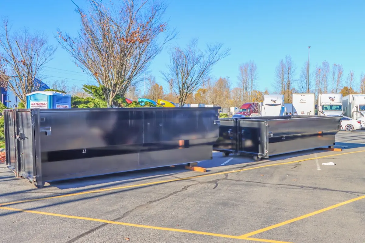 Professional dumpster rental service with roll-off container on residential driveway in Manchester-by-the-Sea